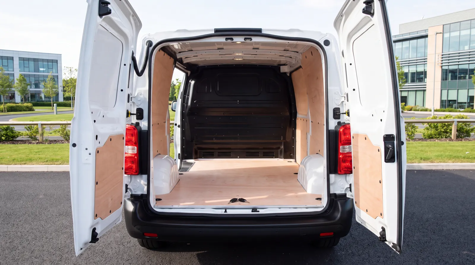 The empty ply-lined load bay of a brand-new van with keys resting on the load lip